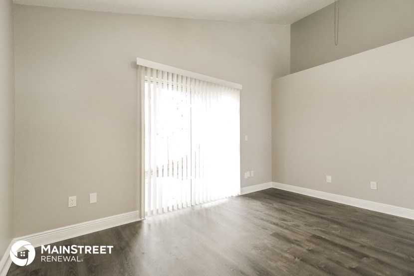 a living room with wood floors and a large window