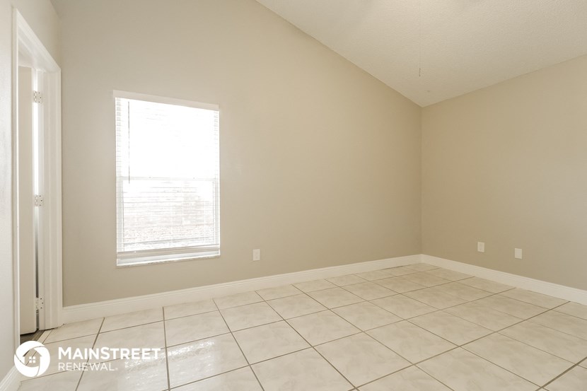 an empty room with a window and a tiled floor