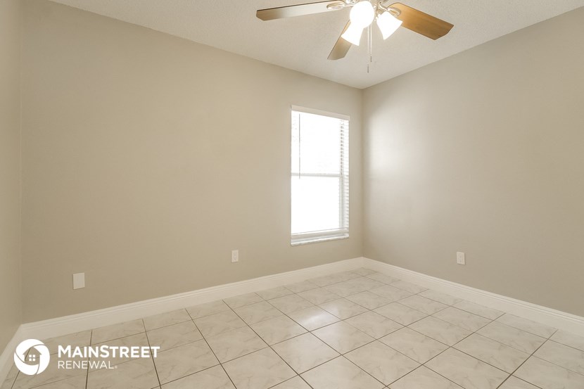 a empty room with a ceiling fan and a window