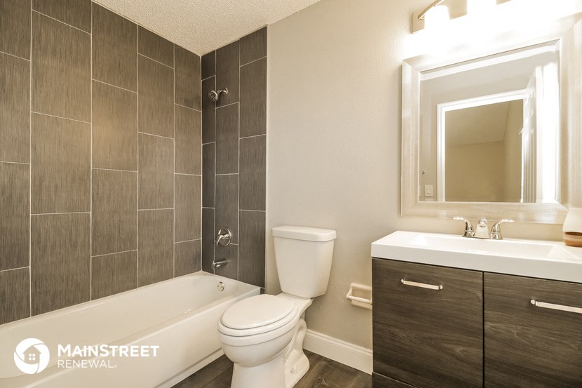 a bathroom with a toilet sink and tub and a mirror