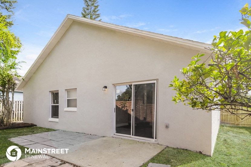 a small white house with a patio and a glass door