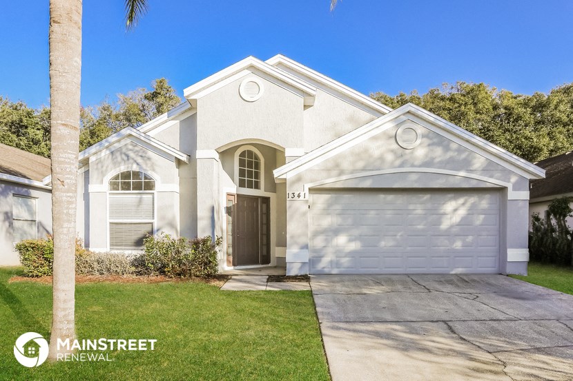 a white house with a white garage door and a lawn