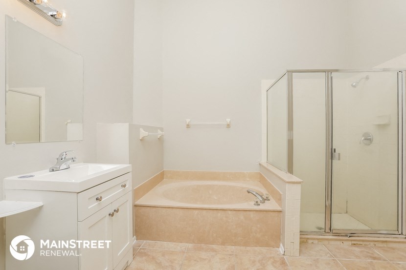 a bathroom with a tub and a shower and a sink