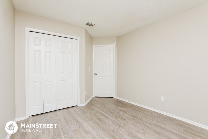 the spacious living room with two closets and wood flooring