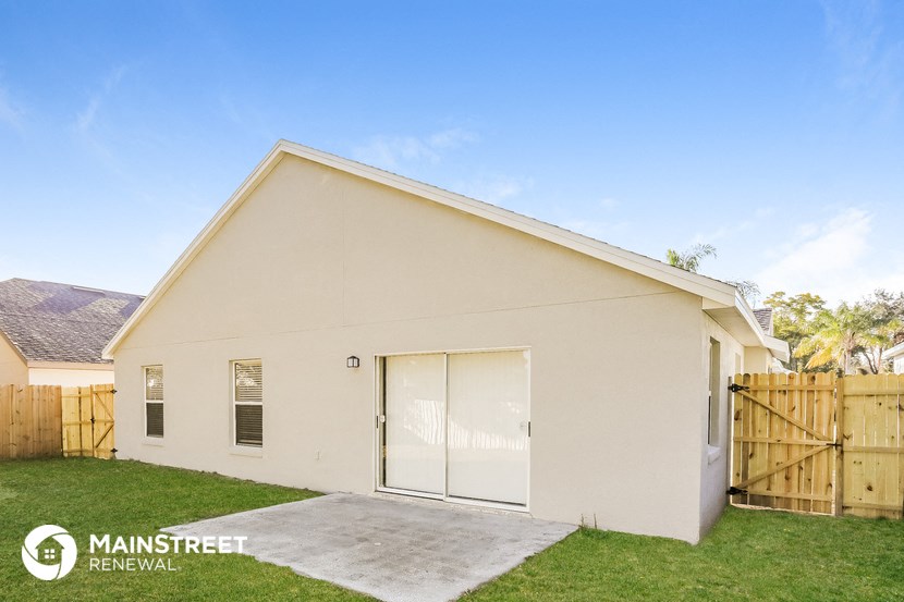 the outside of a garage with a driveway and grass