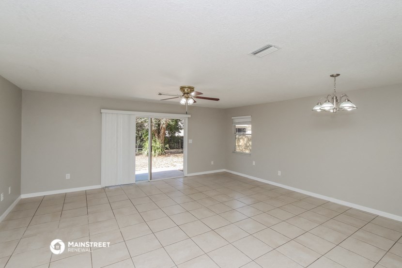 an empty living room with a ceiling fan