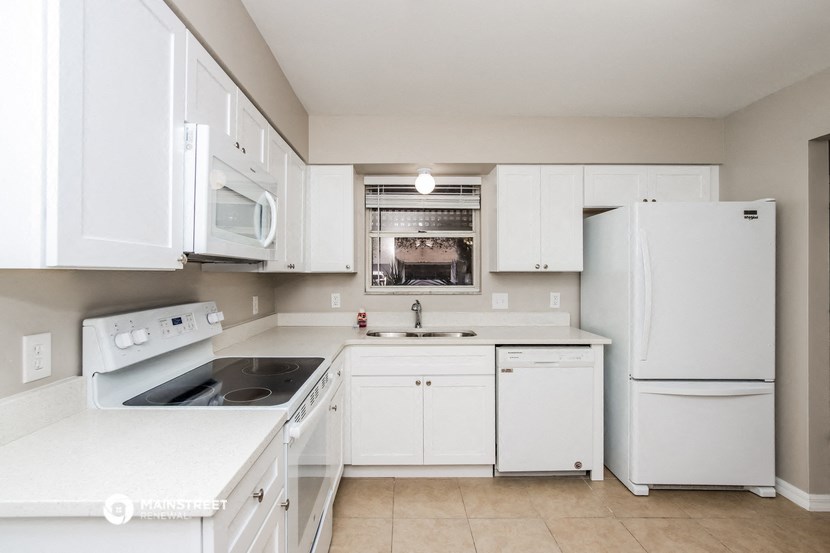 a white kitchen with white appliances and white cabinets