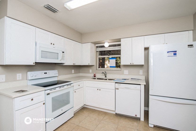 a white kitchen with white appliances and white cabinets