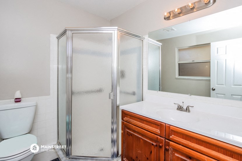 a bathroom with a shower and a sink and a toilet