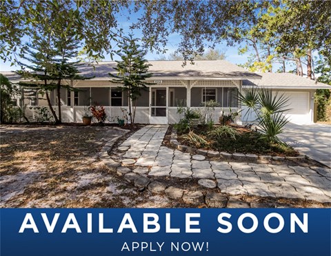 a white house with a yard and a stone driveway