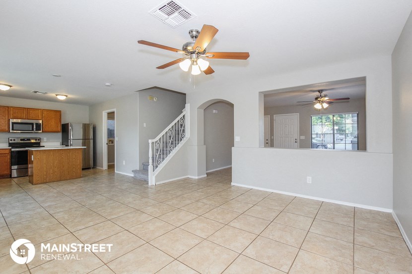 an open kitchen and living room with a ceiling fan