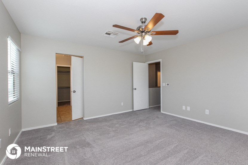 the living room of an apartment with a ceiling fan