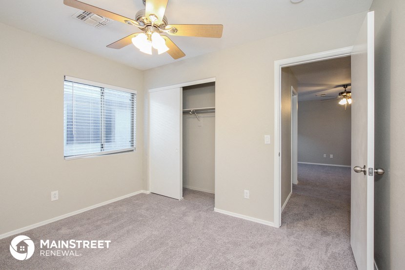 a bedroom with a ceiling fan and a closet