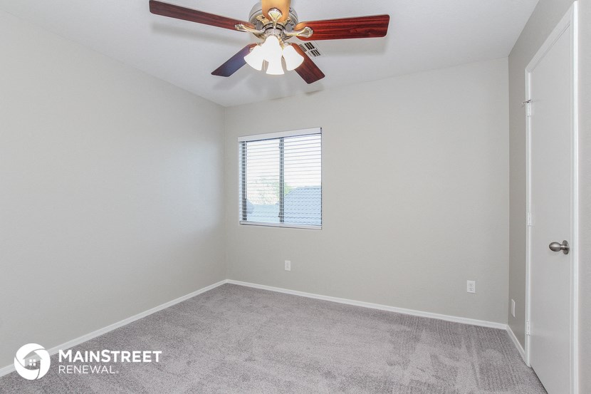 the living room of a new home with a ceiling fan