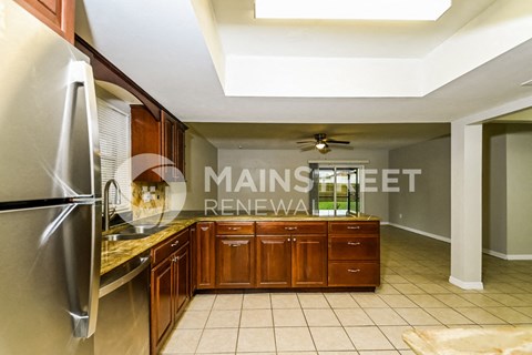 a kitchen with wooden cabinets and a sink and a refrigerator