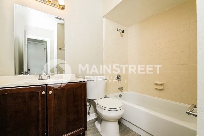 a bathroom with a toilet and a bath tub and a sink
