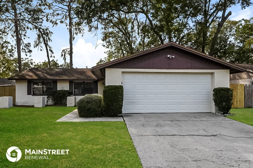 a home with a white garage door and a lawn
