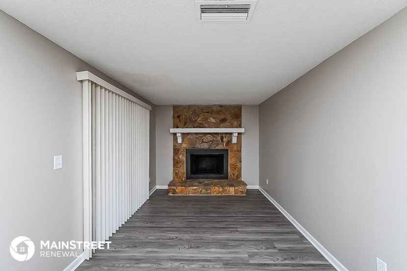 a living room with a fireplace and wooden floors