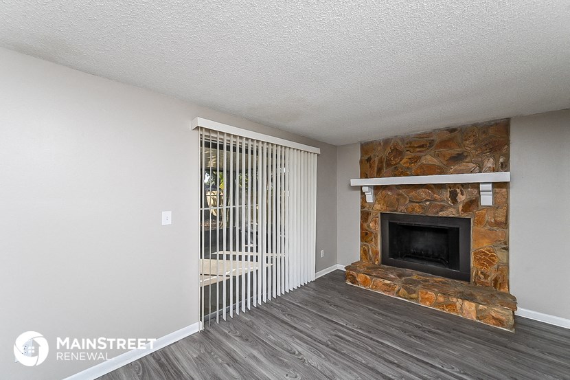the living room has a fireplace and wood flooring