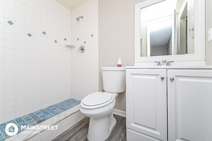 a bathroom with a toilet and a sink and a mirror