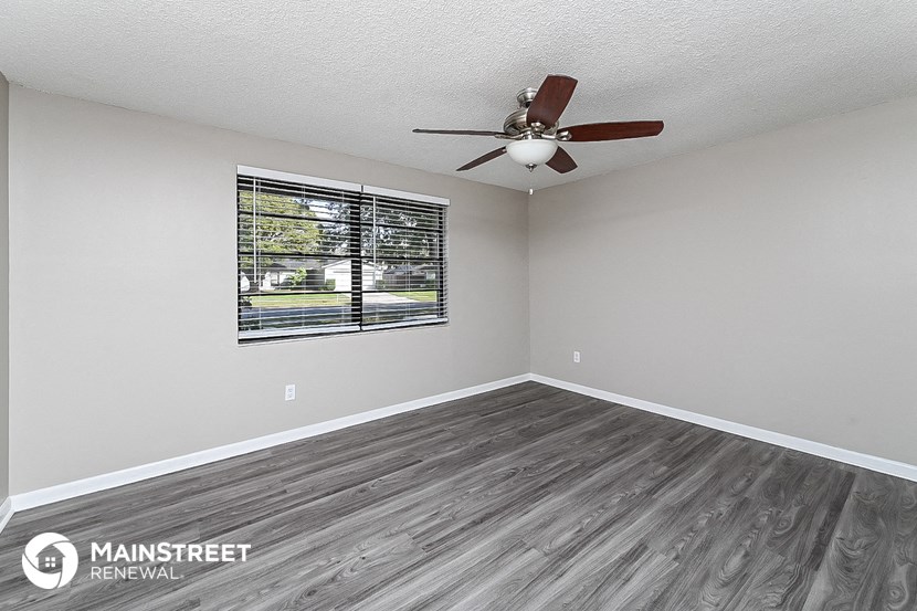 the living room of our studio apartment atrium with wood floors and a ceiling fan