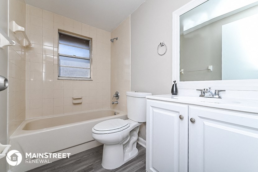 a bathroom with a toilet and a tub and a sink