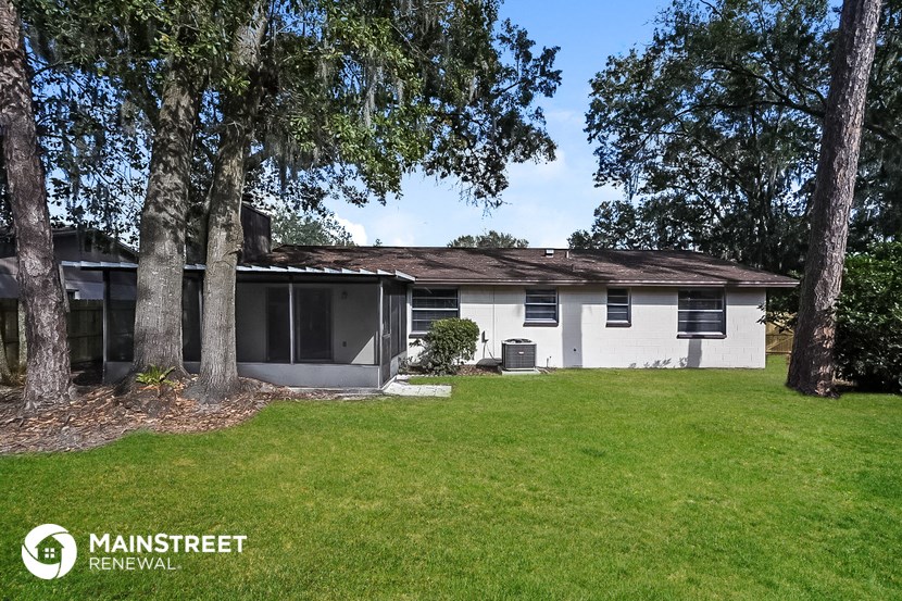 a white house with a yard and trees