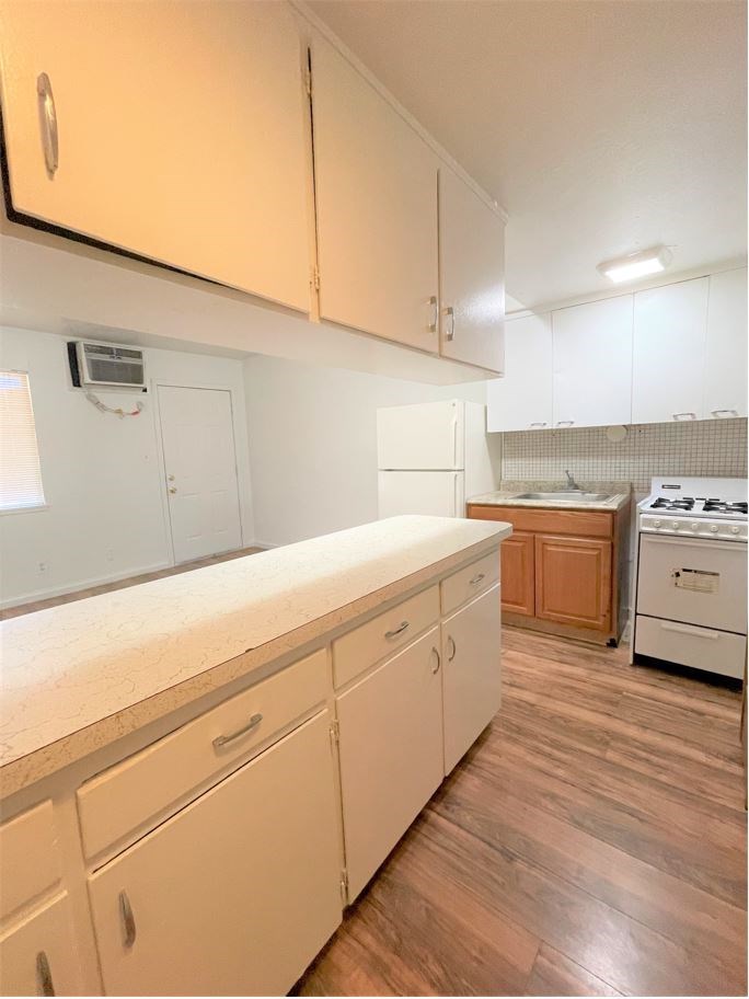 an empty kitchen with white cabinets and a counter top