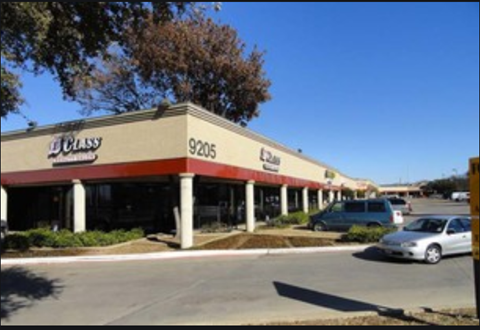 an empty gas station with cars parked in a parking lot