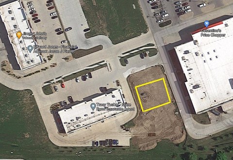 A satellite image shows a parking lot and a building with a yellow square highlighting a specific area.