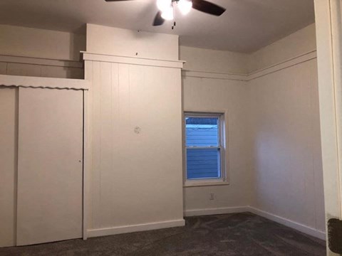 A room with a window and a ceiling fan.