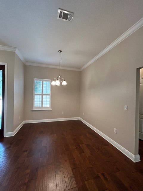 A room with wooden floors and a chandelier.