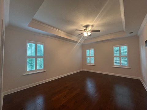 A room with wooden floors and a ceiling fan.