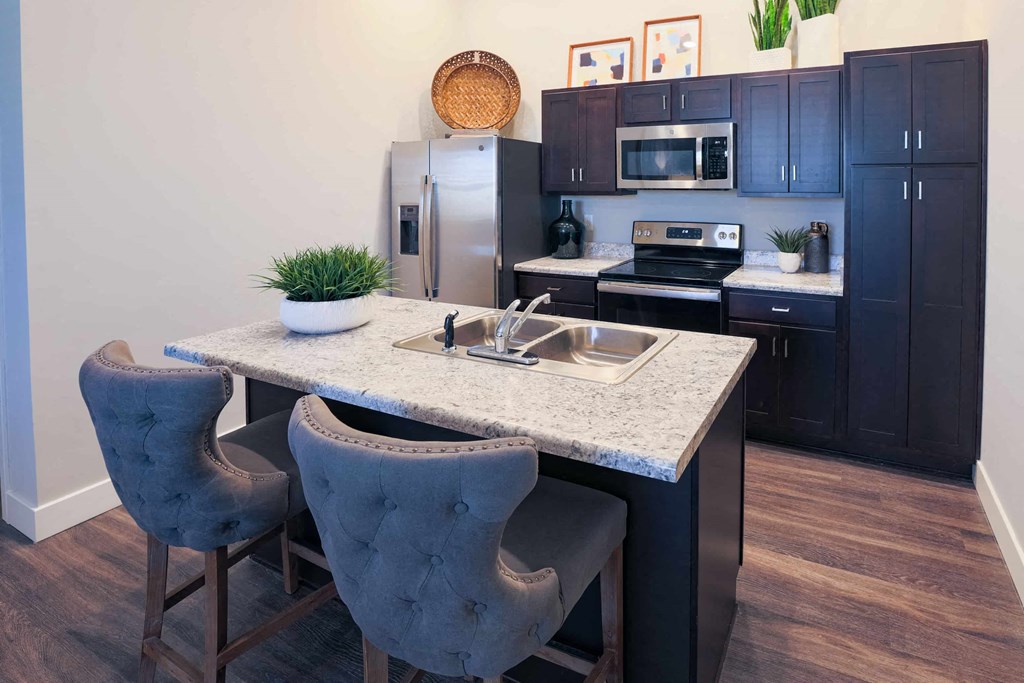 a kitchen with a marble counter top and black cabinets