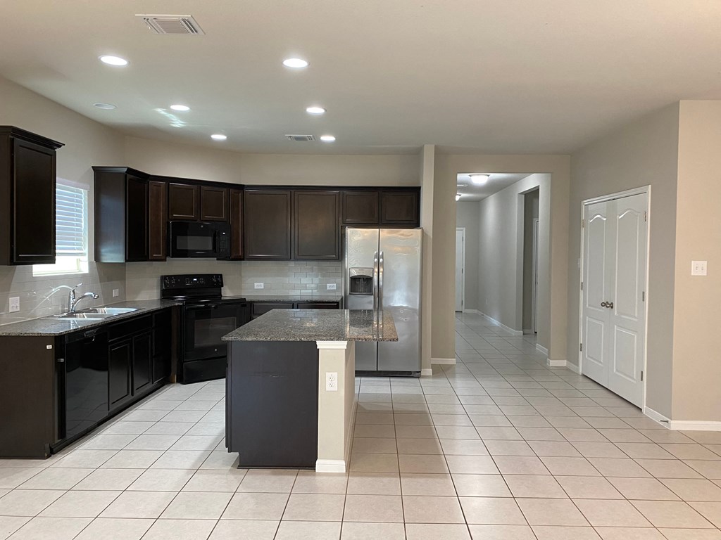 a kitchen with black cabinets and a counter top
