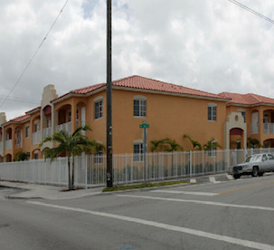 a large building with a fence in front of a street