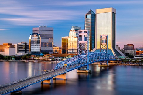 A cityscape with a blue bridge crossing a body of water.