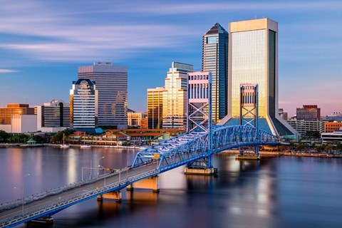 A cityscape with a blue bridge crossing a body of water.