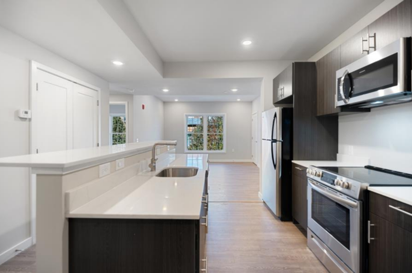 a modern kitchen with white counter tops and a sink