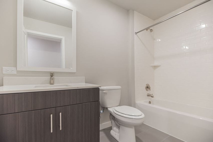 a bathroom with a toilet sink and shower and a mirror