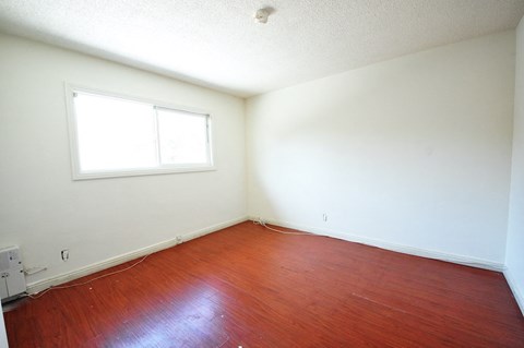 a empty room with wooden floors and a window
