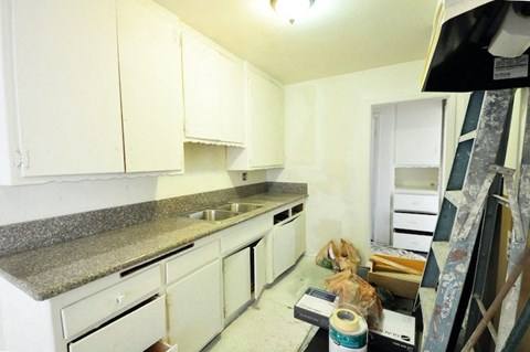 a kitchen is being remodeled with white cabinets and marble counter tops