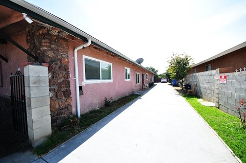 an empty sidewalk in front of a brick building