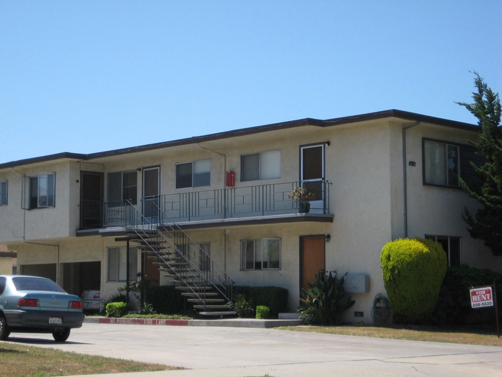 an apartment building with a car parked in front of it