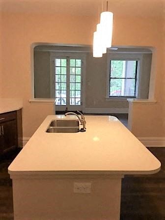 A kitchen island with a sink and a window above it.