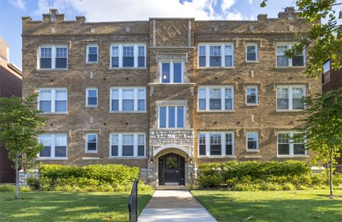 A large brick building with a gate in front.