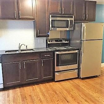 A kitchen with a stove, oven, microwave, and refrigerator.