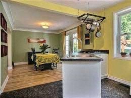 A kitchen with yellow walls and a white island.