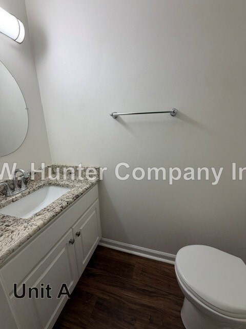 A white toilet in a bathroom with a sink and a mirror.