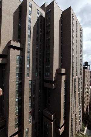 A tall building with many windows is seen from a low angle.